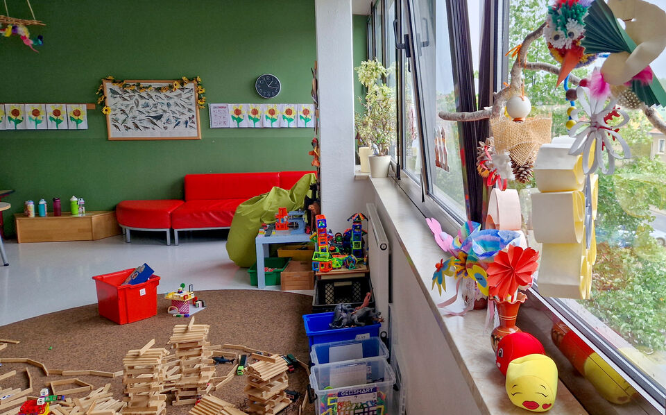 Hortzimmer mit großen Fenstern, Couch und Spielzeug