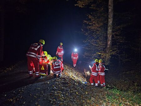 Einsatzkräfte orientieren sich bei Nacht im Wald