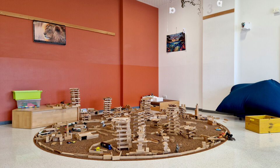 Spielecke mit Spielteppich und Holzbausteinen