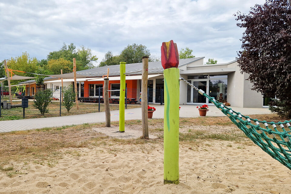 DRK Kita Knirpsenland: Teil des Außenspielplatzes, Bungalow im Hintergrund