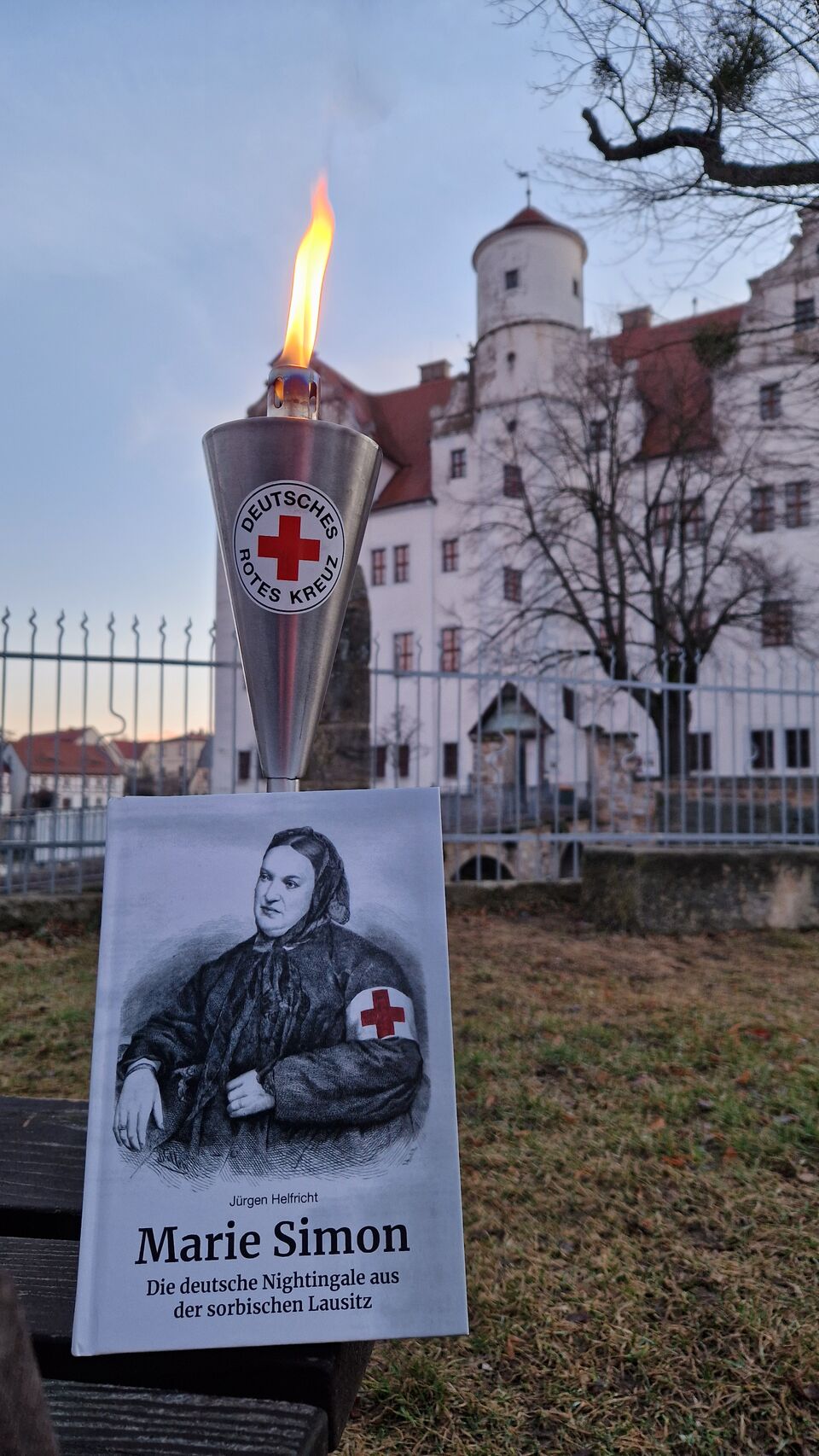 Ein Buch über Marie Simon mit brennender Fackel, im Hintergrund ein Schloss