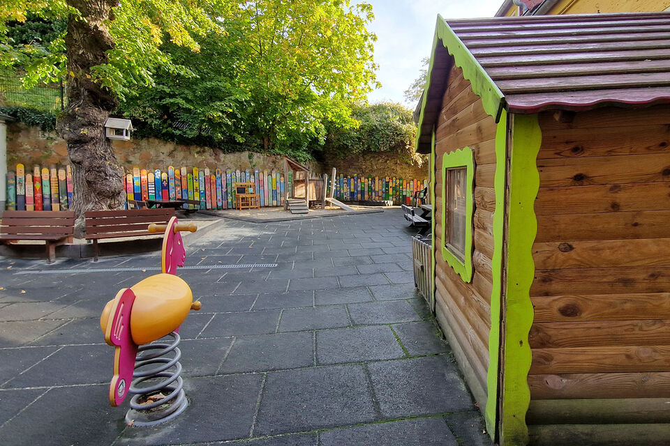 Außenbereich mit Spielehaus und Schaukeltier